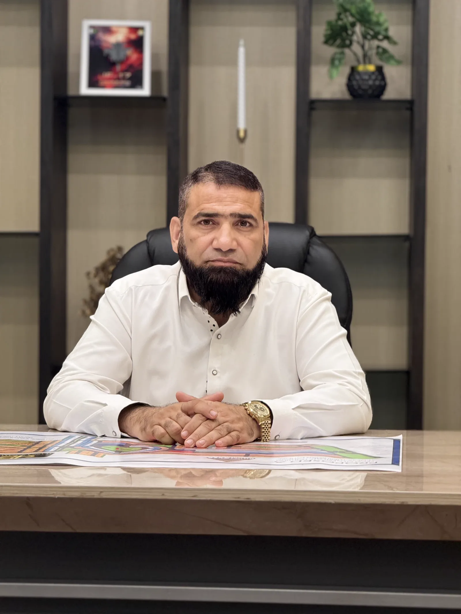 The founder of MS Alam Enterprise seated at his desk with a Prism City master plan spread in front of him.